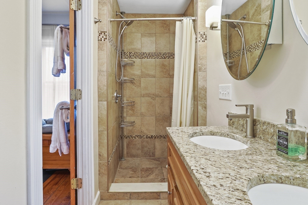 42 Partridge Street Boston, MA 02132 - Photo 16 of 33 a bathroom with a granite countertop shower a mirror and a sink