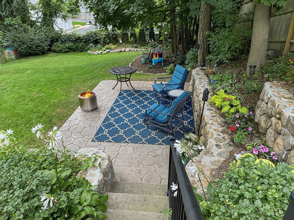 42 Partridge Street Boston, MA 02132 - Photo 30 of 33 a wooden bench sitting in the middle of a garden