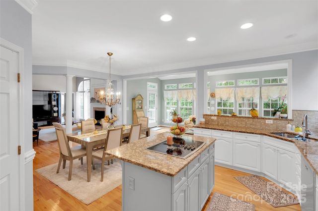 a large kitchen with granite countertop a large counter top stainless steel appliances and cabinets