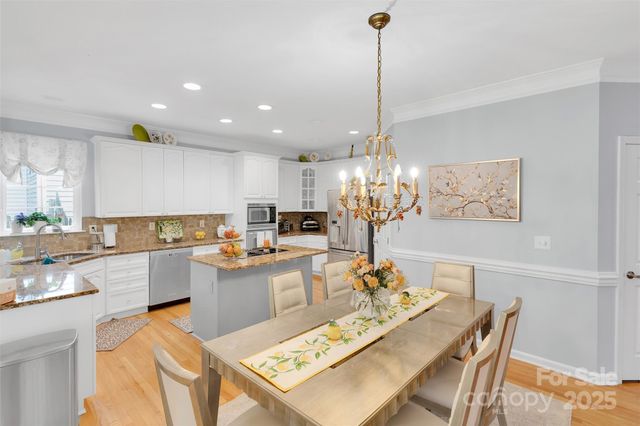 a living room with furniture kitchen view and a chandelier