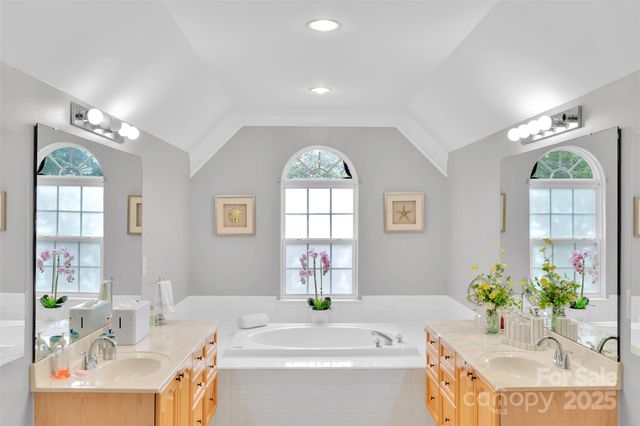 a spacious bathroom with a granite countertop tub sink and mirror
