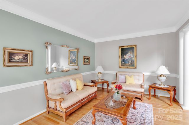 a living room with furniture a fireplace and a chandelier