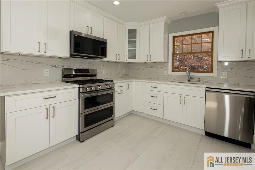 278 Rector Street Perth Amboy, NJ 08861 - Photo 6 of 47 a kitchen with white cabinets stainless steel appliances and window