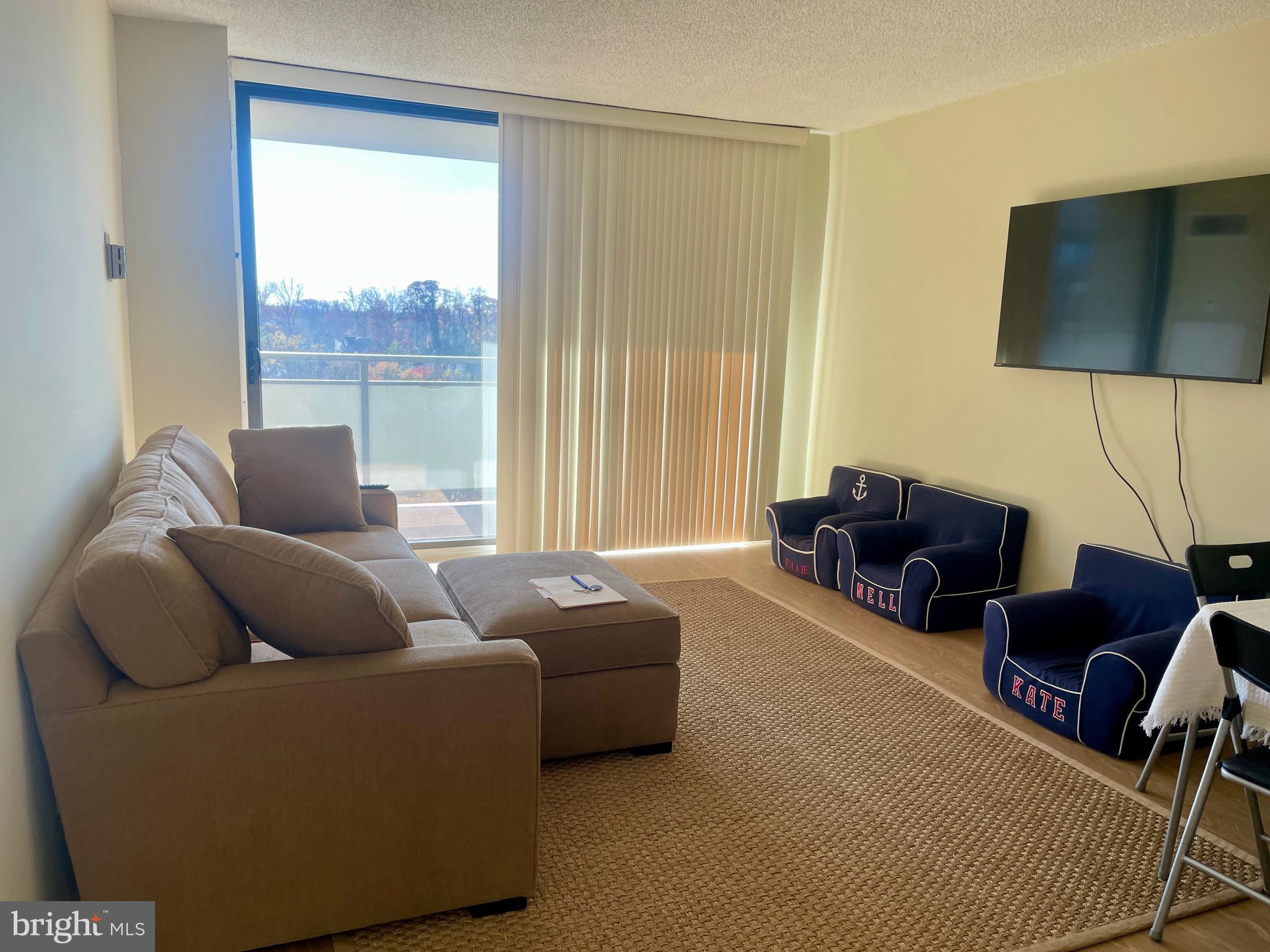 5225 Pooks Hill Road, Unit 1607N Bethesda, MD 20814 - Photo 2 of 51 a living room with furniture and a flat screen tv