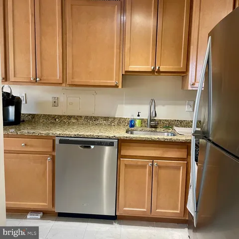 a kitchen with granite countertop cabinets stainless steel appliances and a counter space