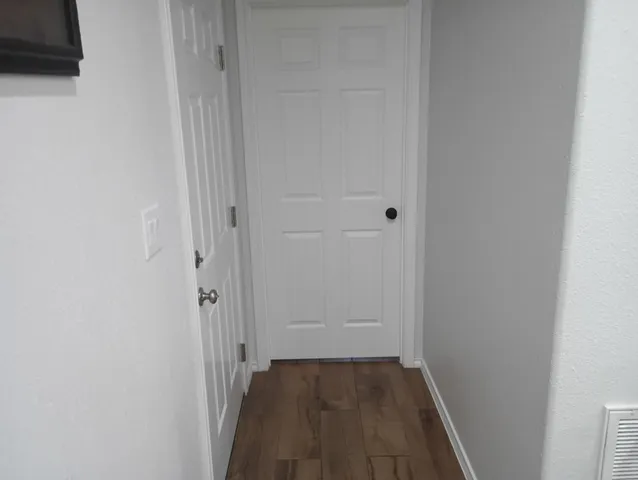a view of a hallway with wooden floor