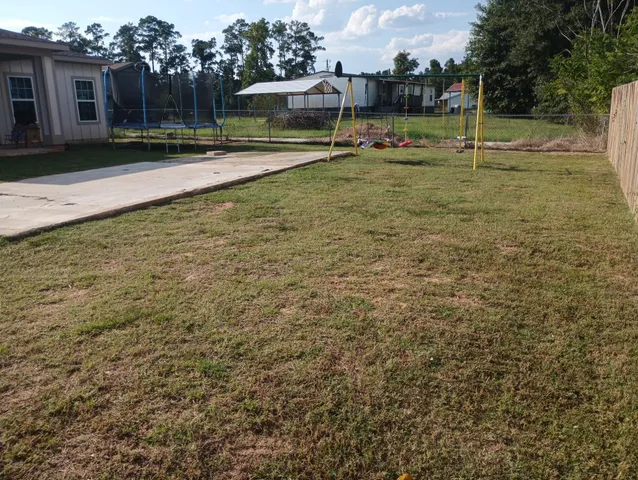 a view of swimming pool with outdoor seating and covered with trees
