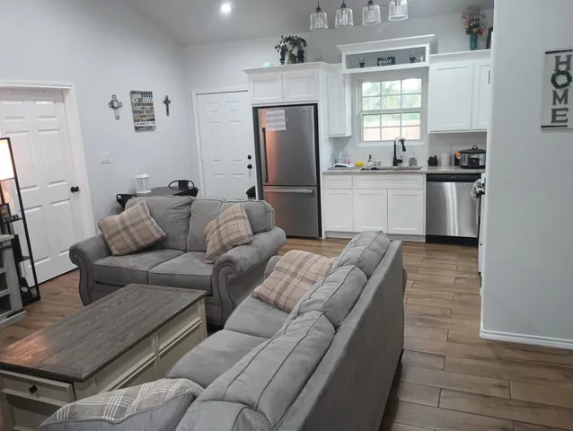 a living room with furniture and kitchen view