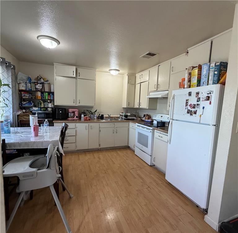 1567 Ellen Court Merced, CA 95341 - Photo 5 of 16 a kitchen with kitchen island a white wooden cabinets and white appliances