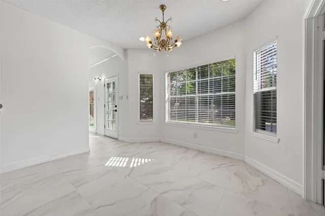 a kitchen with white cabinets granite counter tops and a stove