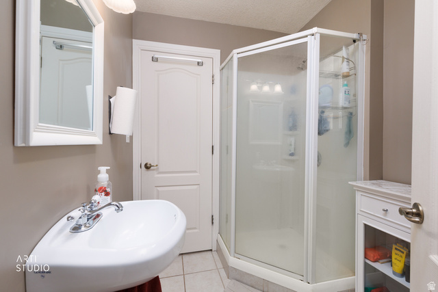16535 South Redwood Road Riverton, UT 84065 - Photo 23 of 59 White pedestal sink with chrome faucet, framed mirror, and a corner shower enclosure