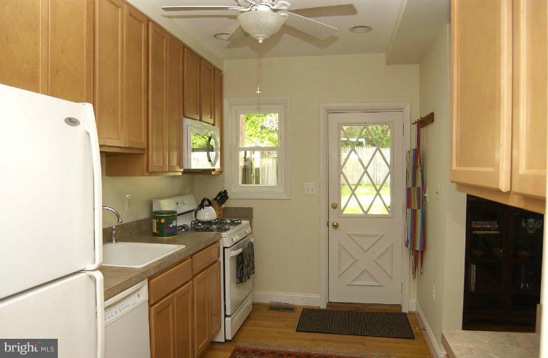645 Coleraine Road Baltimore, MD 21229 - Photo 8 of 28 a kitchen with a sink a stove cabinets and wooden floor