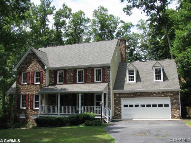 a view of a white house with large windows and a small yard