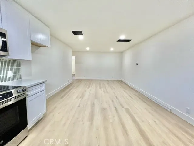 a view of empty room with wooden floor