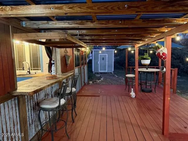 a view of a chairs and table in the patio and a wooden deck