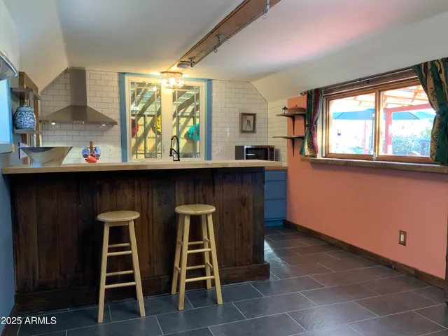a kitchen with granite countertop a sink and chairs