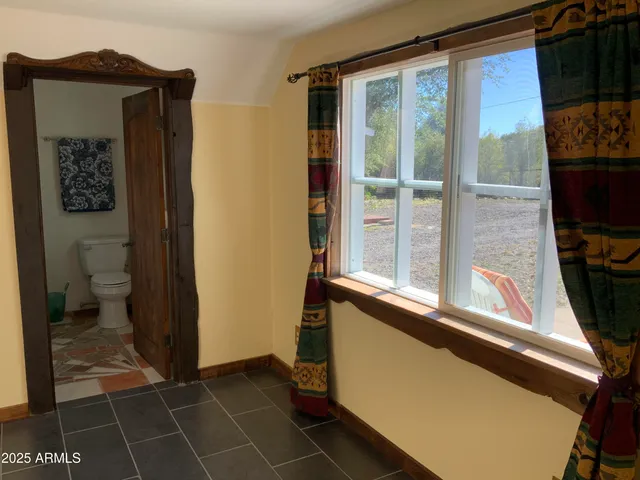 a view of a hallway with wooden floor and a cabinet