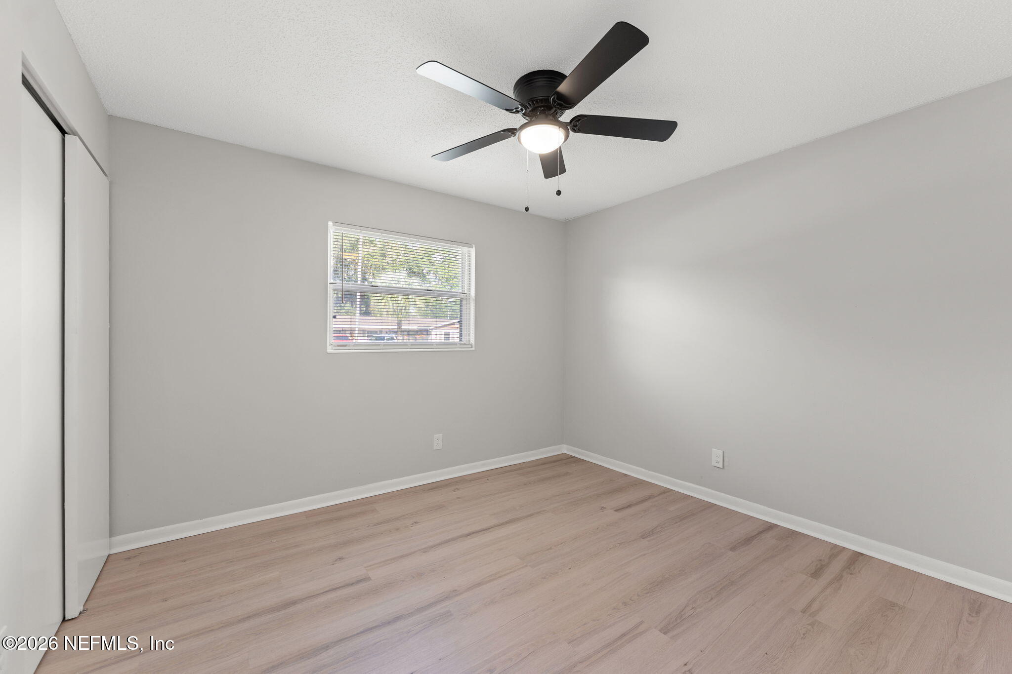 2455 Seaway Street Jacksonville, FL 32233 - Photo 11 of 16 an empty room with wooden floor and ceiling fan