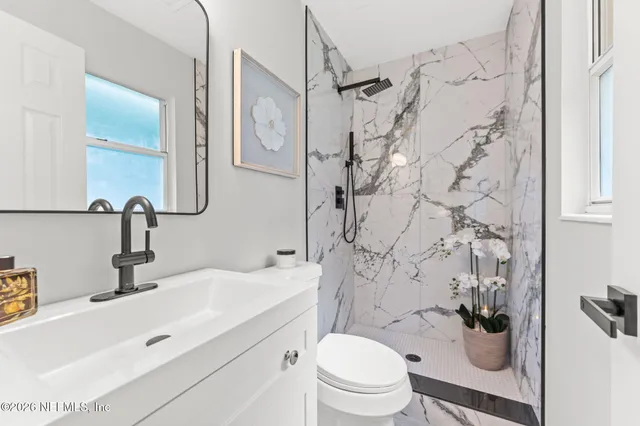 a bathroom with a sink toilet vanity and shower