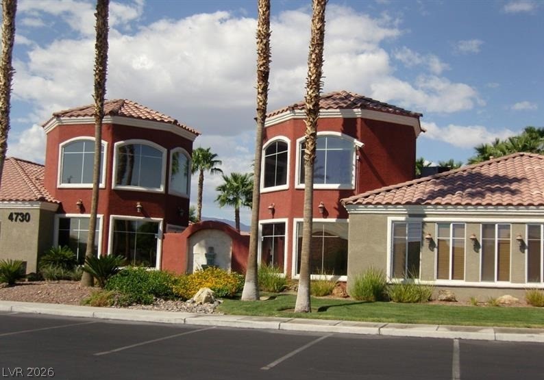 4730 East Craig Road, Unit 2102 Las Vegas, NV 89115 - Photo 13 of 13 Spanish-style architecture with tile roofs and numerous windows, set amidst desert-friendly landscaping.