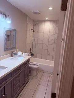a bathroom with a granite countertop sink toilet a mirror and shower