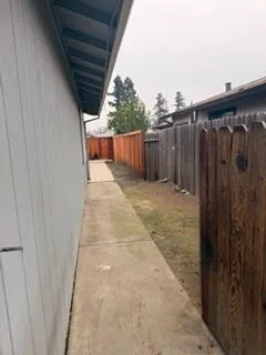 a view of a backyard with wooden fence