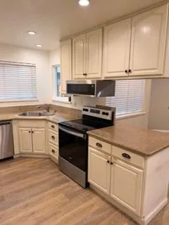 a kitchen with white cabinets and appliances