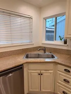 a view with granite countertop a sink and a white cabinets