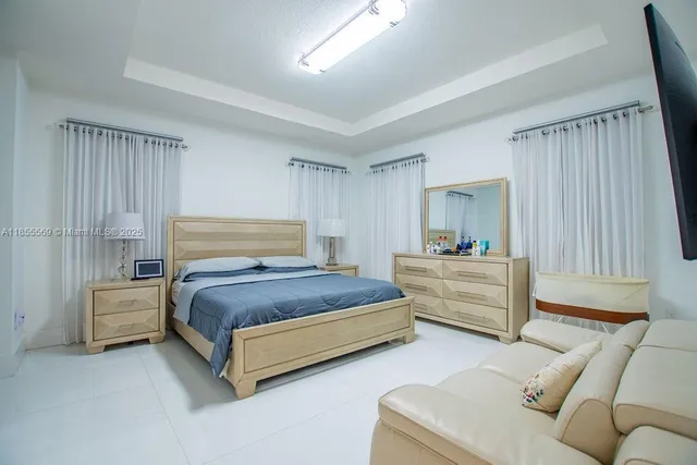 a bedroom with a bed couch and a window