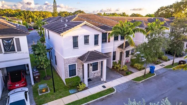 a view of a house with a yard and potted plants