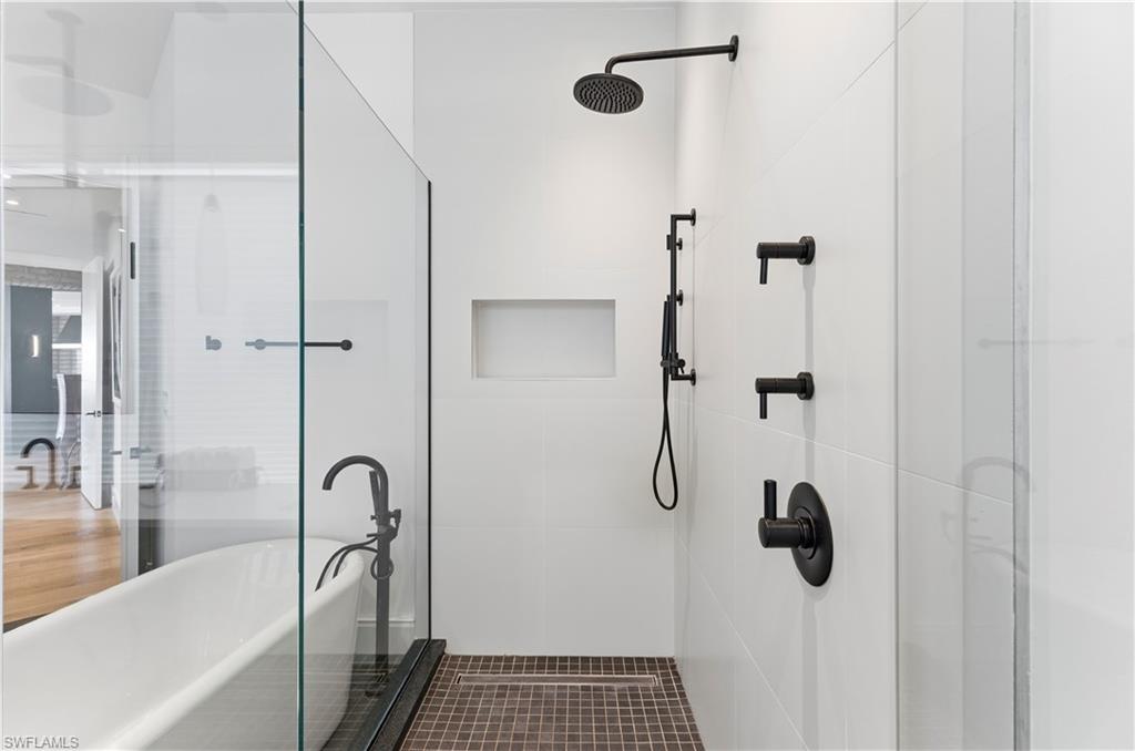 909 10th Street South, Unit 201 Naples, FL 34102 - Photo 19 of 42 Bathroom with a stall shower and a freestanding tub