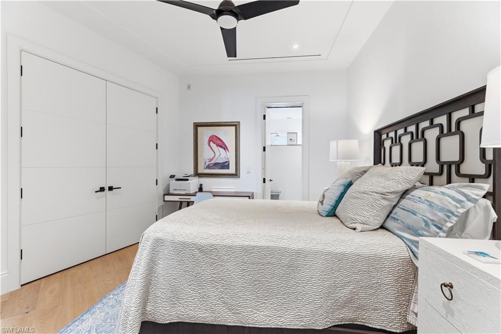 909 10th Street South, Unit 201 Naples, FL 34102 - Photo 39 of 42 Bedroom with light wood-style floors, ceiling fan, and a closet