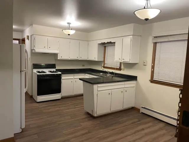 a kitchen with granite countertop a sink cabinets and stainless steel appliances
