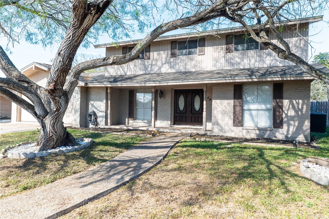 a view of a white house with large windows and a large tree