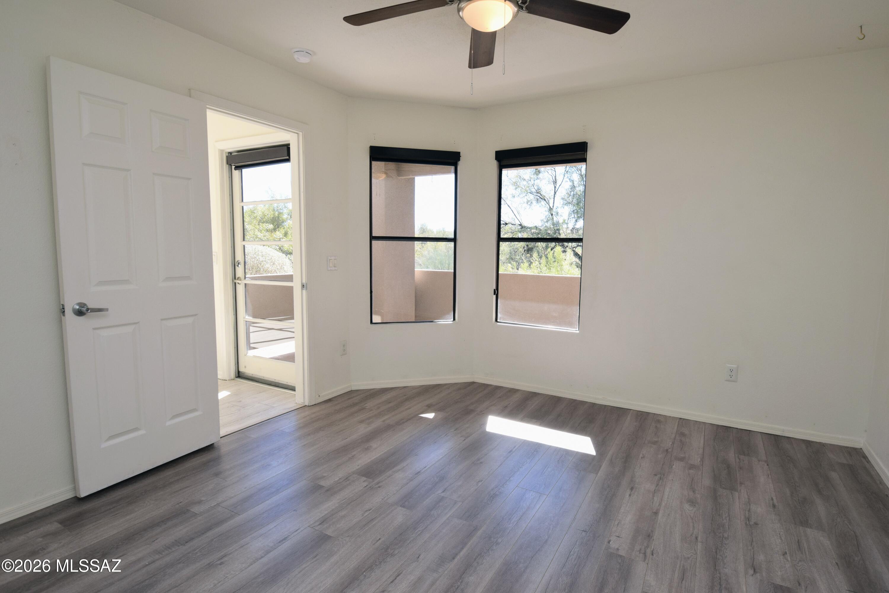 5855 North Kolb Road, Unit 11106 Tucson, AZ 85750 - Photo 21 of 36 an empty room with wooden floor fan and windows