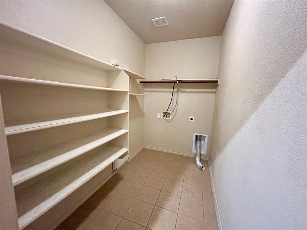 3105 Pecan Tree Drive Denton, TX 76210 - Photo 12 of 25 Washroom featuring light tile patterned floors, hookup for a washing machine, a textured wall, and hookup for an electric dryer