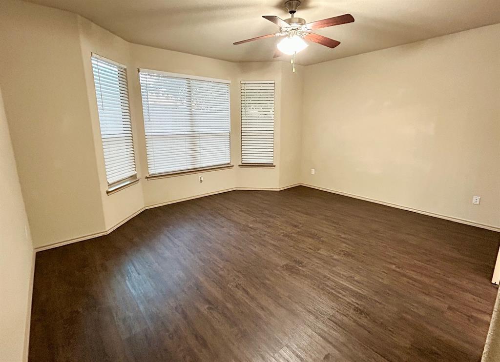 3105 Pecan Tree Drive Denton, TX 76210 - Photo 14 of 25 Empty room with dark wood-type flooring and ceiling fan