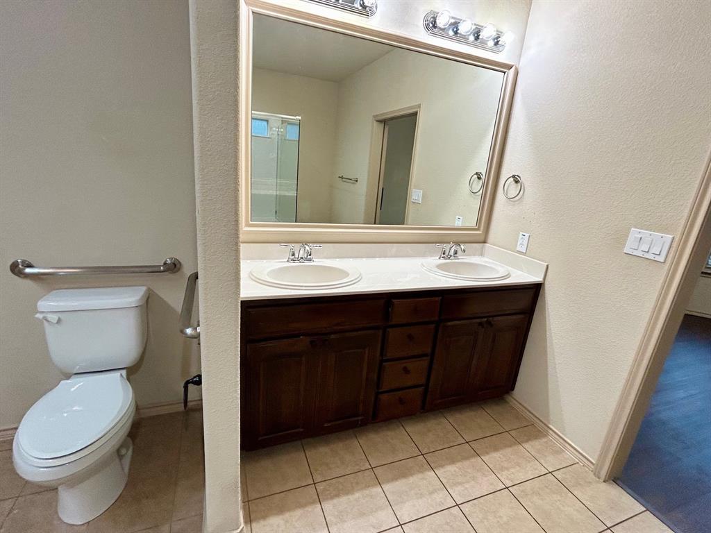 3105 Pecan Tree Drive Denton, TX 76210 - Photo 17 of 25 Full bathroom featuring a textured wall, double vanity, and light tile patterned floors