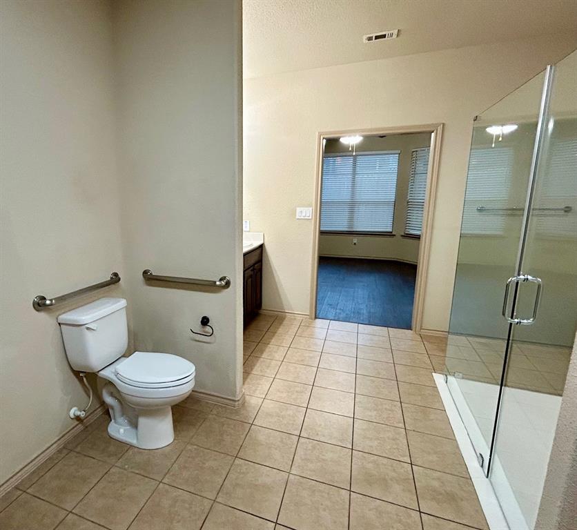 3105 Pecan Tree Drive Denton, TX 76210 - Photo 18 of 25 Full bathroom featuring vanity, light tile patterned flooring, and a shower stall