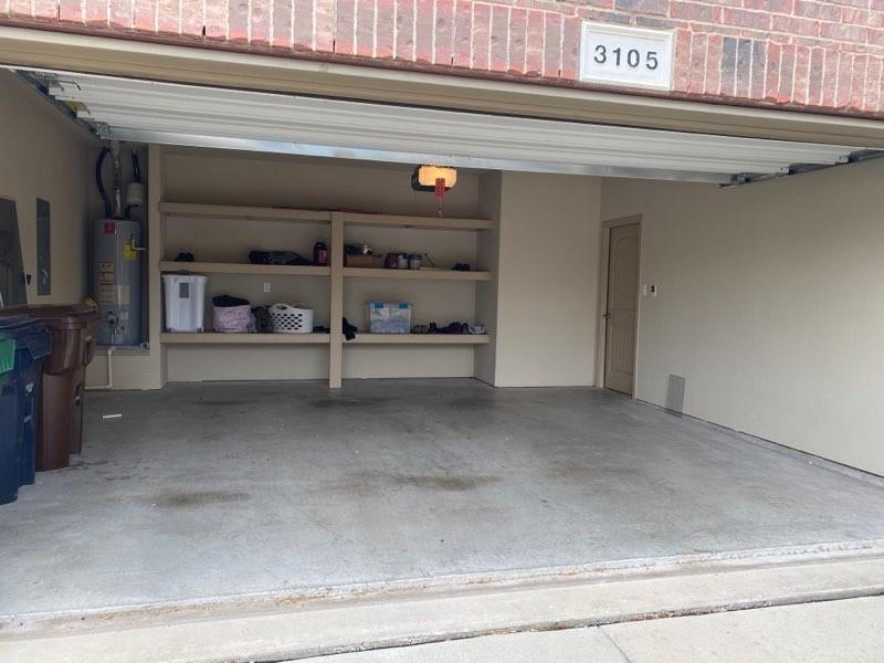 3105 Pecan Tree Drive Denton, TX 76210 - Photo 24 of 25 Garage featuring water heater and a garage door opener