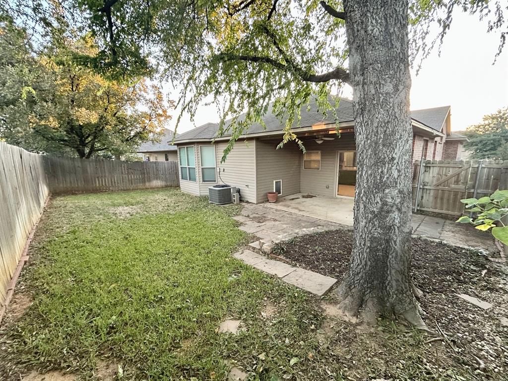 3105 Pecan Tree Drive Denton, TX 76210 - Photo 4 of 25 Back of house with a fenced backyard, a patio, and roof with shingles