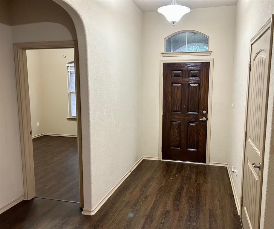 3105 Pecan Tree Drive Denton, TX 76210 - Photo 5 of 25 Foyer with plenty of natural light, arched walkways, dark wood-type flooring, and a textured wall