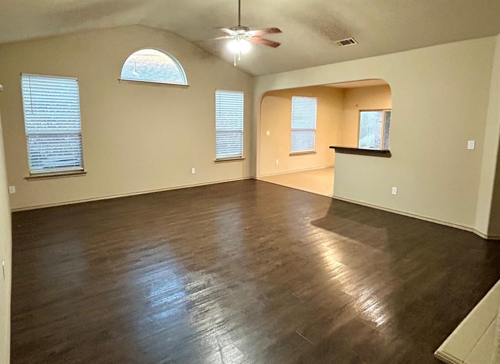 3105 Pecan Tree Drive Denton, TX 76210 - Photo 7 of 25 Unfurnished room featuring dark wood-style floors, arched walkways, lofted ceiling, and ceiling fan