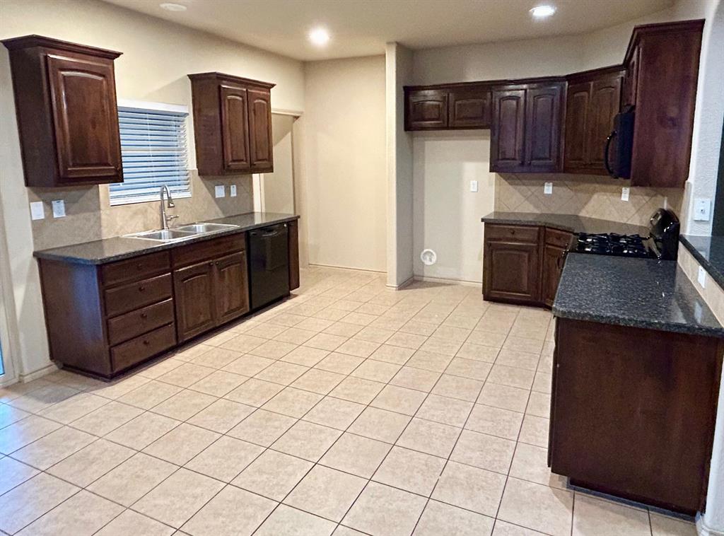 3105 Pecan Tree Drive Denton, TX 76210 - Photo 9 of 25 Kitchen featuring backsplash, dark brown cabinetry, light tile patterned flooring, dark stone counters, and recessed lighting