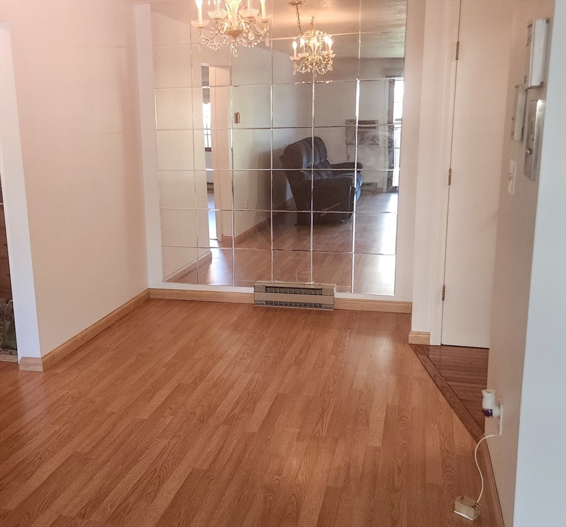 1003 North Main Street, Unit 7 Randolph, MA 02368 - Photo 14 of 31 an empty room with wooden floor and door