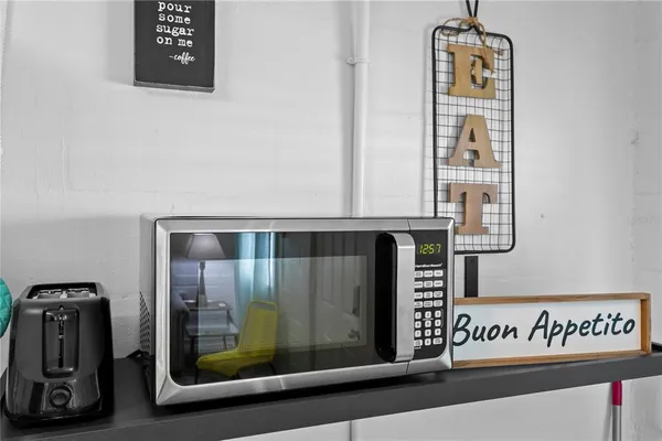 a kitchen with stainless steel appliances a microwave a stove a table and chairs