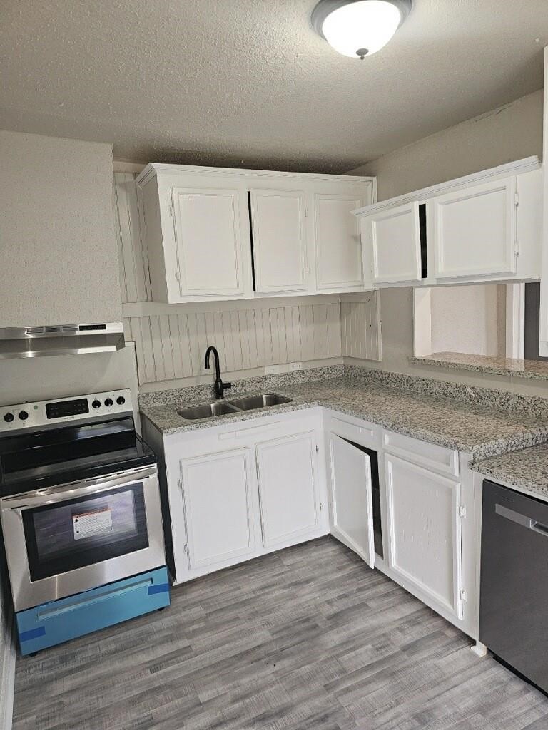 8010 Miley Street Houston, TX 77028 - Photo 2 of 8 a kitchen with granite countertop a stove a sink and a microwave