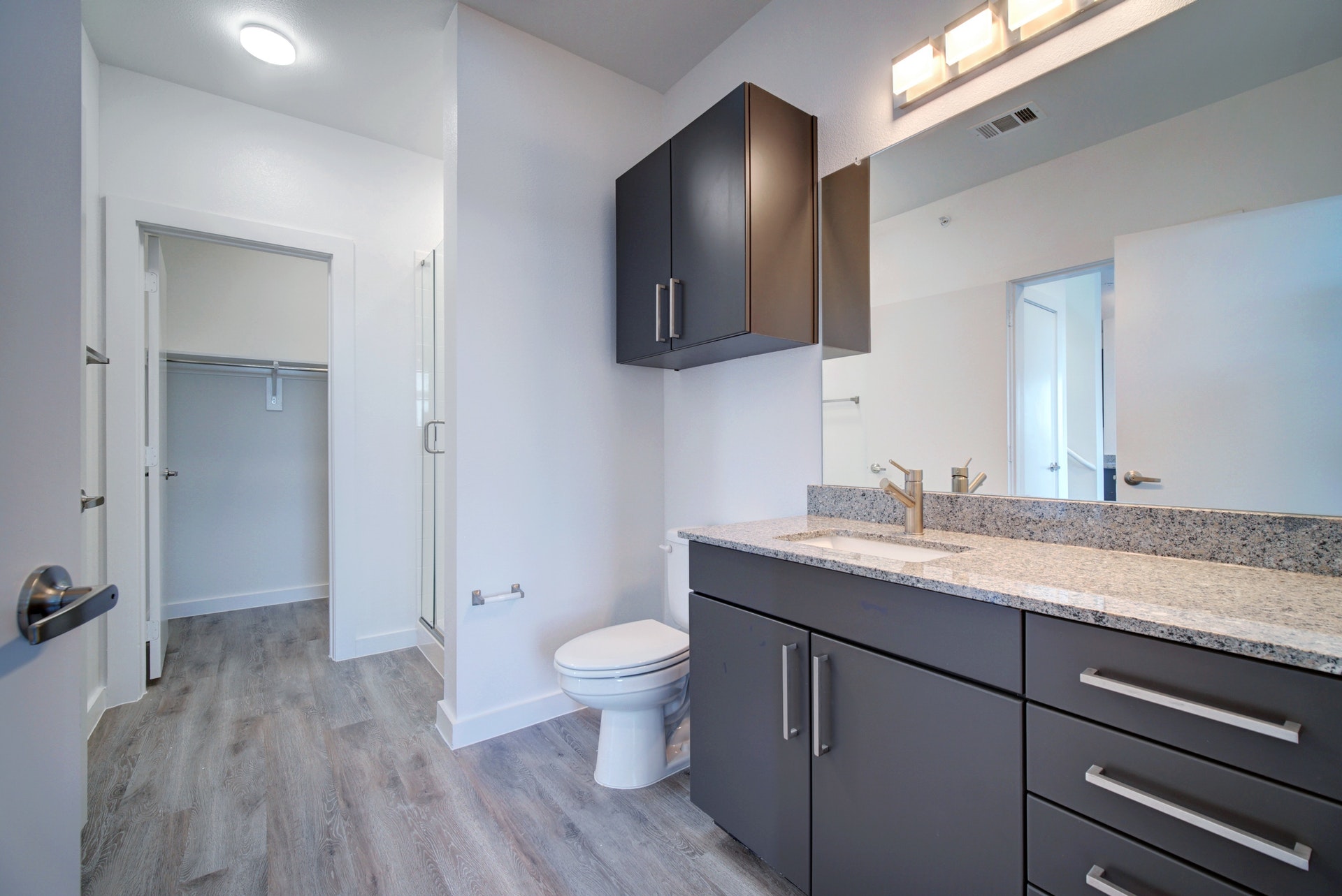 13130 Pond Springs Road, Unit 3214 Austin, TX 78729 - Photo 18 of 40 Full bath with vanity, a walk in closet, a stall shower, and light wood finished floors