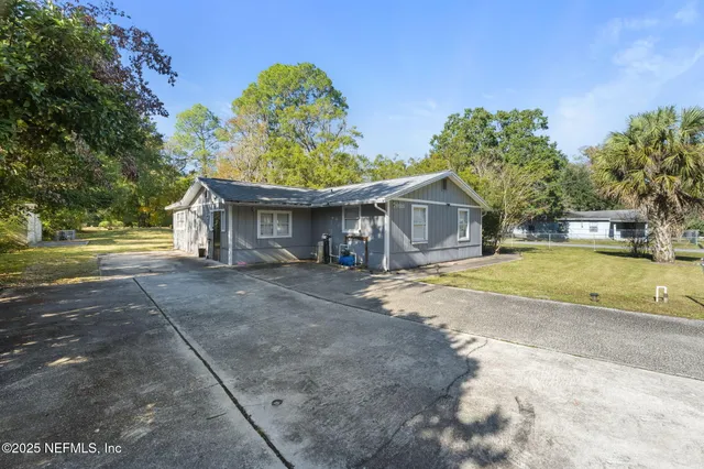 a view of a house with a yard and large tree