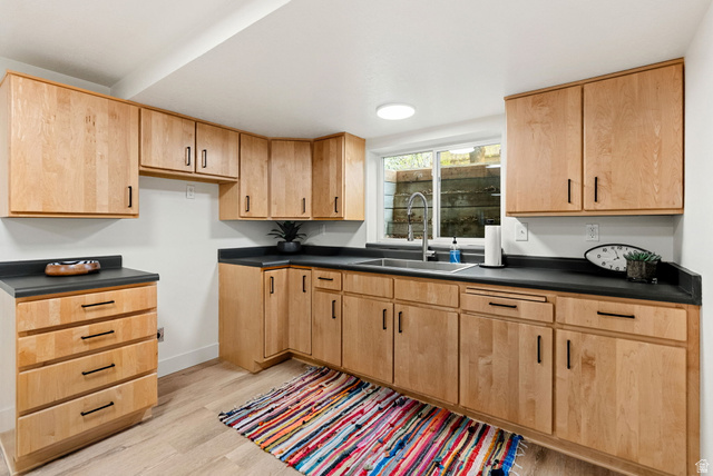 368 Spring Creek Road Providence, UT 84332 - Photo 27 of 45 Kitchen featuring dark countertops, light wood-style floors, and light wood finish cabinets